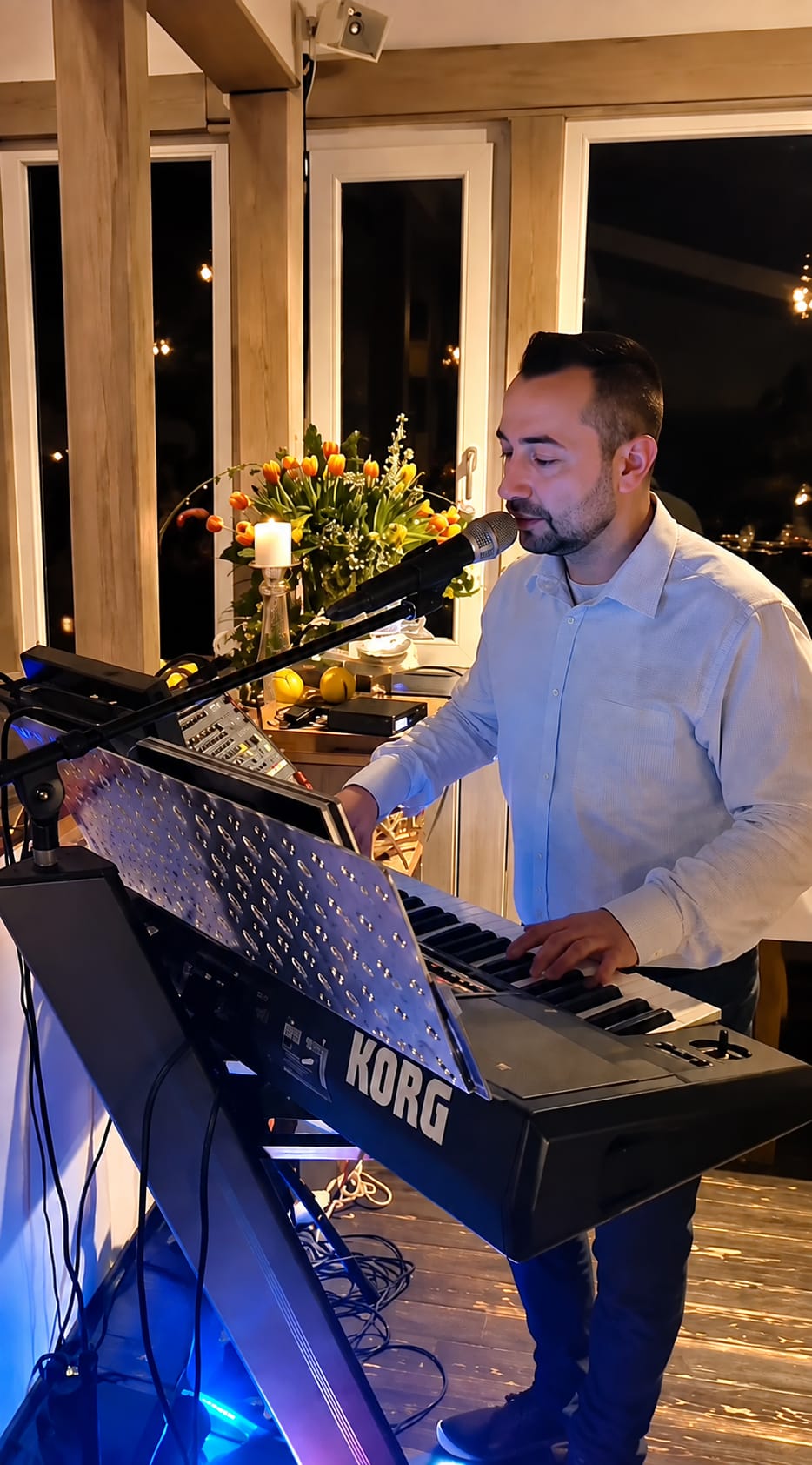Salva Ditta singt am Keyboard bei einem Auftritt, Abendstimmung mit Lichterketten